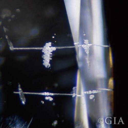 A close up of a diamond with a laser drilled hole.