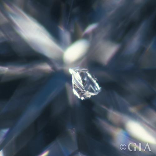 A close up of a diamond with a bruise in it.