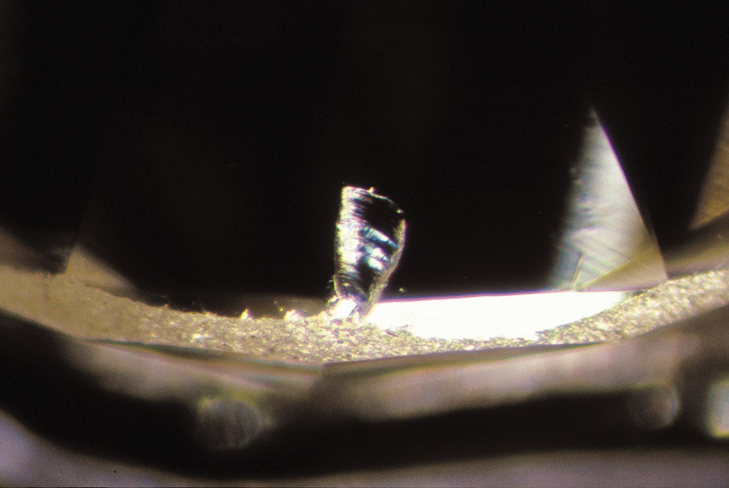 A close up of a diamond with a chip in it.