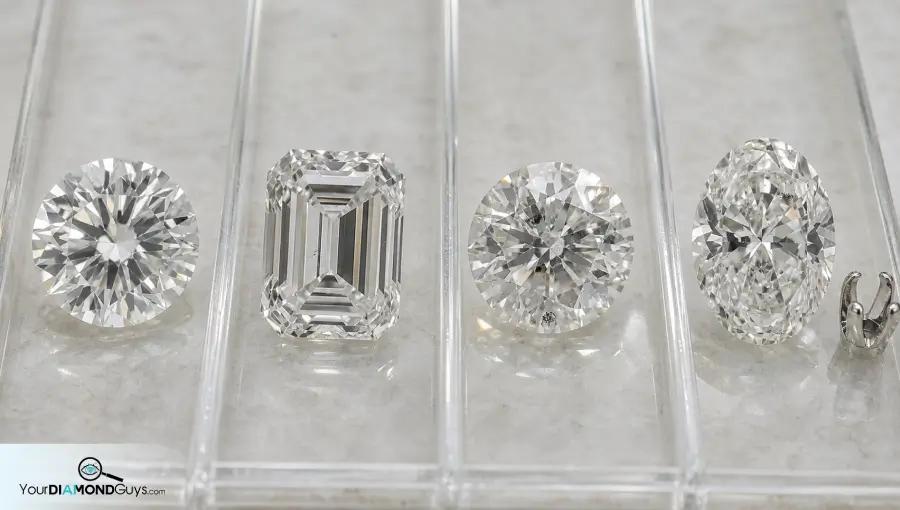 Four loose diamonds in clear inspection lanes showing clean SI round VS step cut I clarity risk and edge inclusion prong check