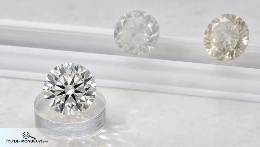 Bright transparent round diamond separated from two sleepy hazy diamond candidates