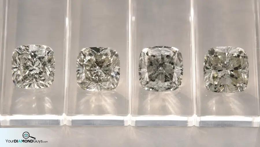 Four cushion diamonds in acrylic lanes showing light dense table and cloudy twinning wisp checks