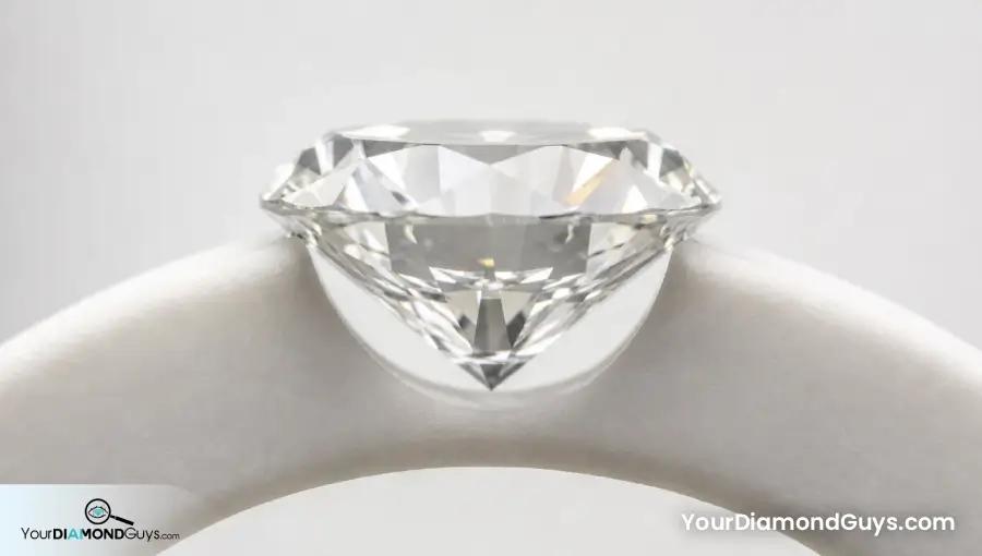 Low side view of a balanced round brilliant showing its table edge, symmetrical crown slopes, girdle, pavilion, and culet