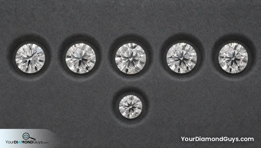 Five similarly sized round diamonds with one visibly smaller face up outlier