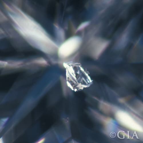 A close up of a diamond with a bruise in it.