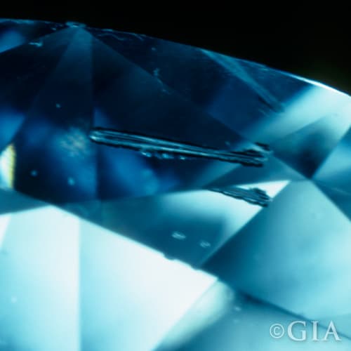 A close up of a diamond with a needle in it.