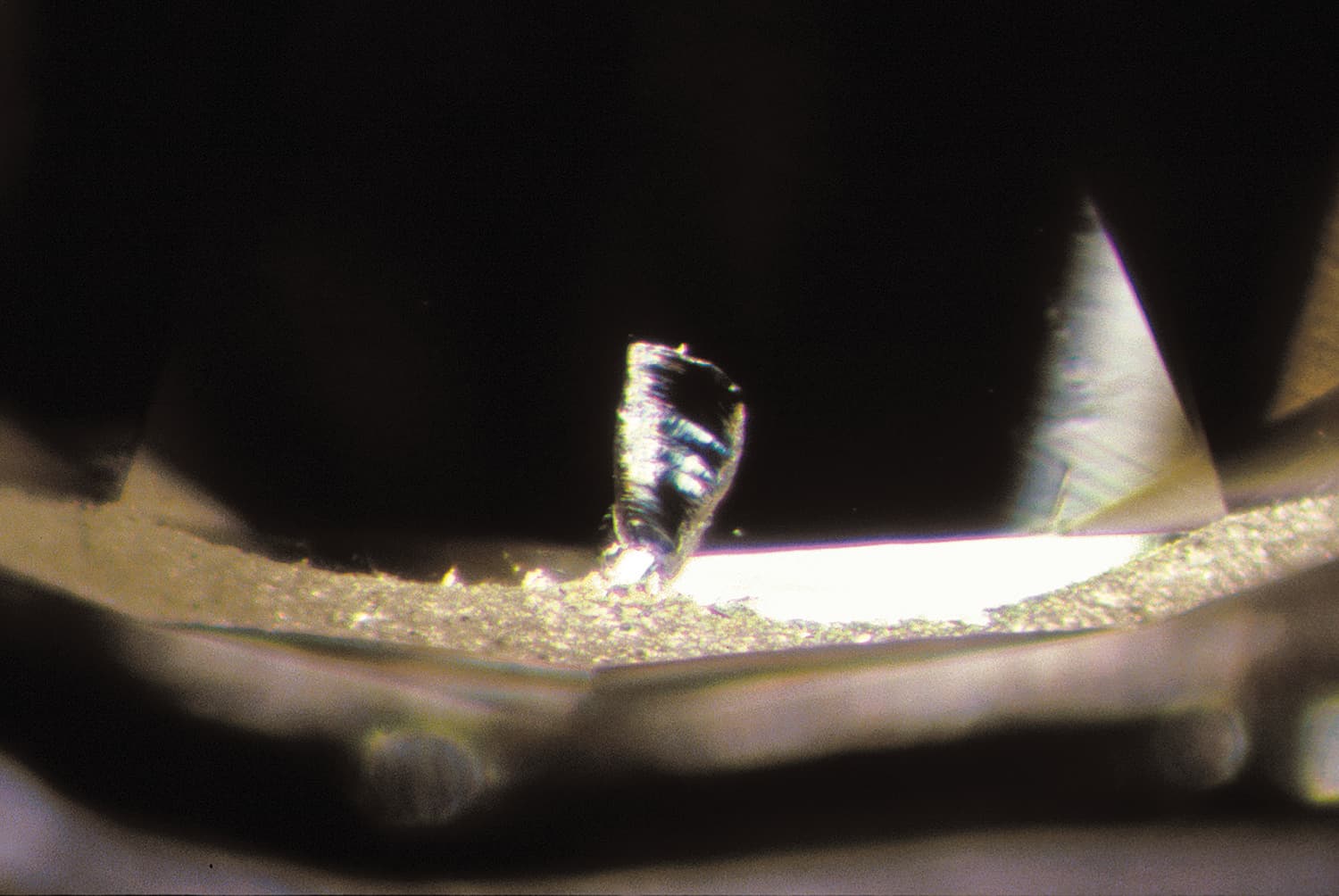 A close up of a diamond with a chip in it.