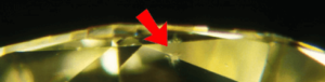 A close up of a diamond with a needle in it.