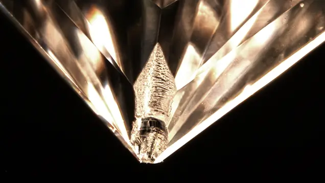 Magnified stepped chip at the corner of a princess cut diamond.