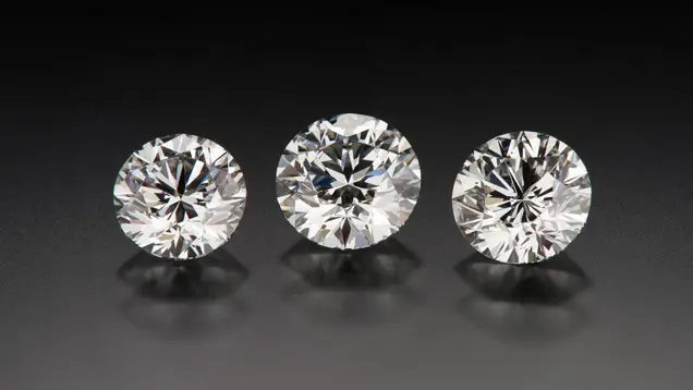 Three round brilliant diamonds photographed face up, all graded Very Good by GIA, with different sizes and contrast patterns