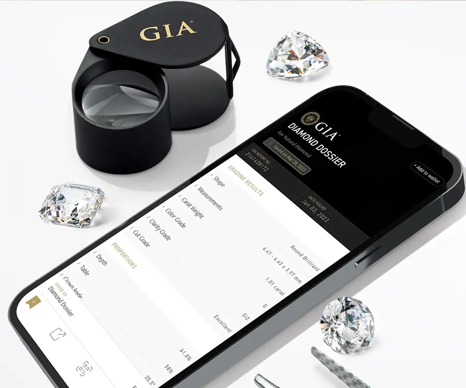 GIA Diamond Dossier on a phone beside a jeweler’s loupe and loose diamonds.