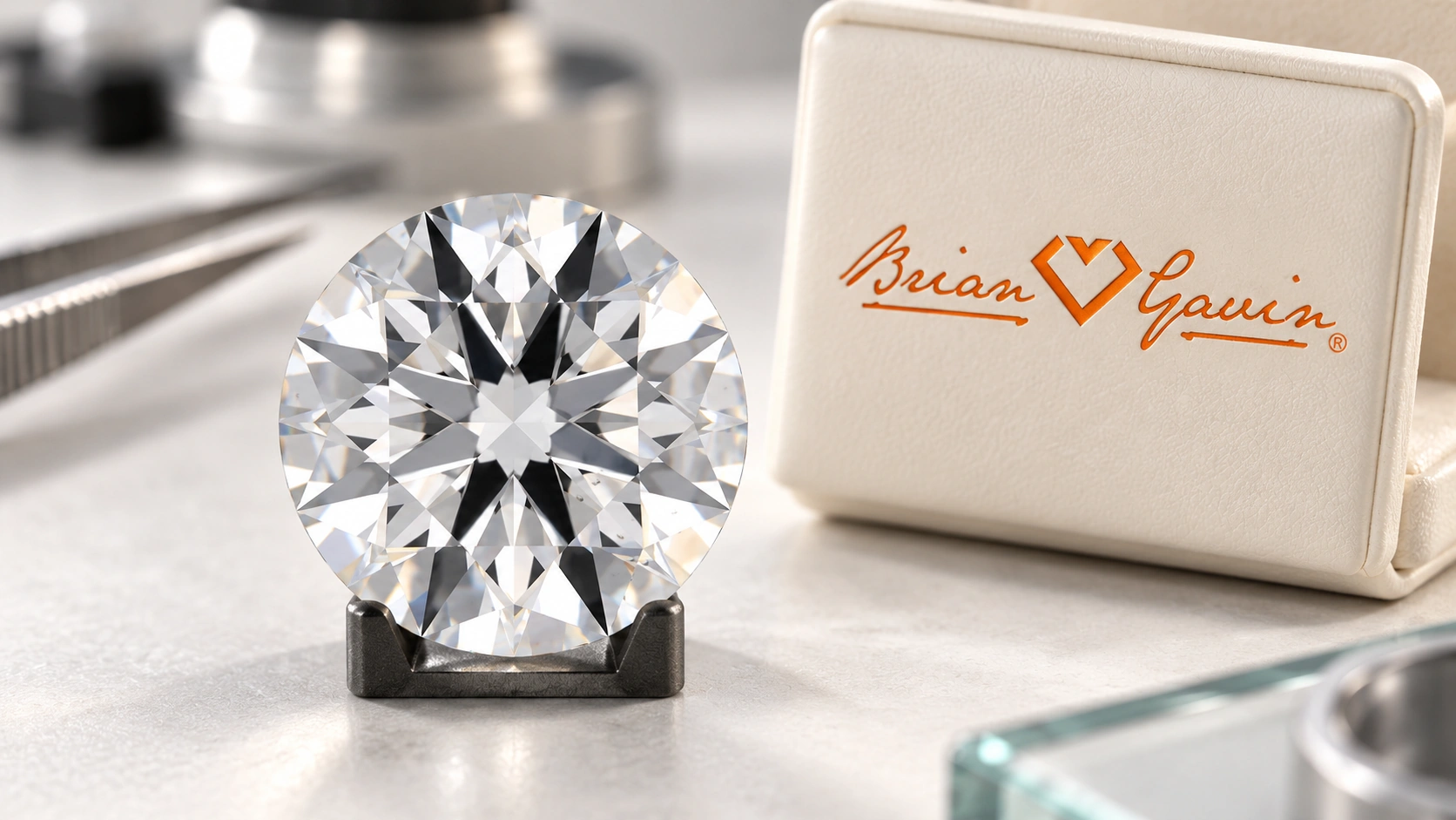 Editorial round brilliant diamond on a small inspection cradle beside a cream presentation case bearing the Brian Gavin logo